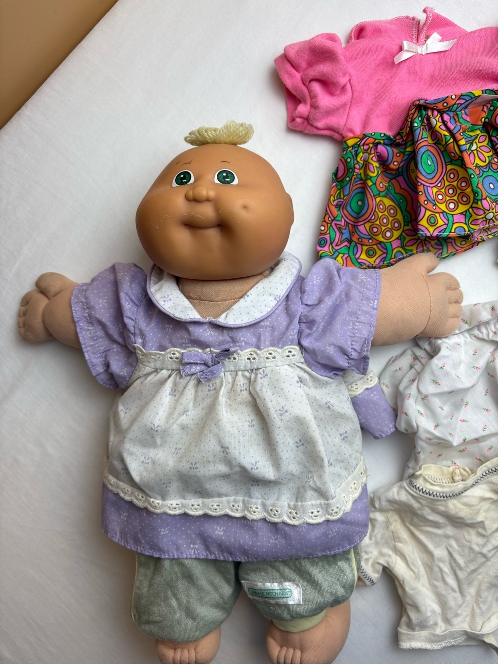 Lavender-Accented Plush Baby Doll with White Apron with extra clothes as is